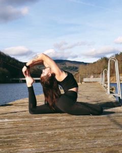 Anais fait du yoga sur le ponton d'un lac